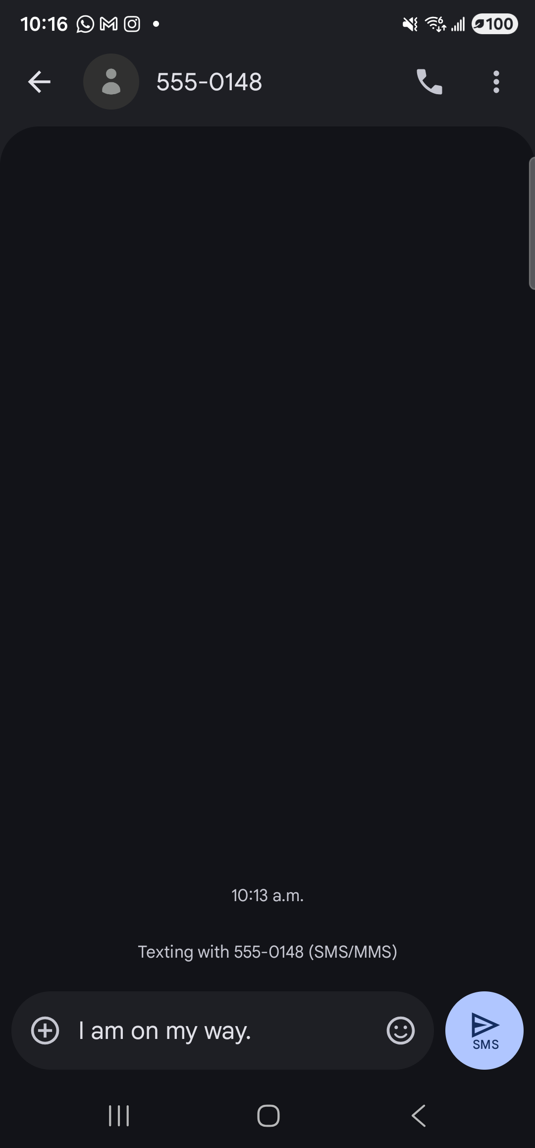 The Google Messages SMS app full-screen on the Galaxy S23 Ultra in dark mode. At the top: a back arrow, a generic gray-circle contact avatar, the recipient ‘555-0148’, and on the right a phone-call icon and a three-dot overflow menu. Below: a large mostly-empty conversation pane with a centered timestamp ‘10:13 a.m.’ followed by ‘Texting with 555-0148 (SMS/MMS)’. At the bottom, the input row: a ‘+’ attachment button, the message field reading ‘I am on my way.’ with a smiley emoji and image-picker icon to its right, and a round blue circular ‘SMS’ send button at the far right. The keyboard is hidden. The message has not been sent.